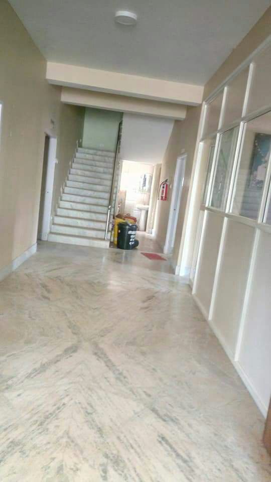 Marble-floored corridor with a staircase and a red fire extinguisher on the wall